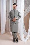 A man wearing a sand grey luxury formal Kameez Shalwar with a straight cut waistcoat and a patch pocket waistcoat.