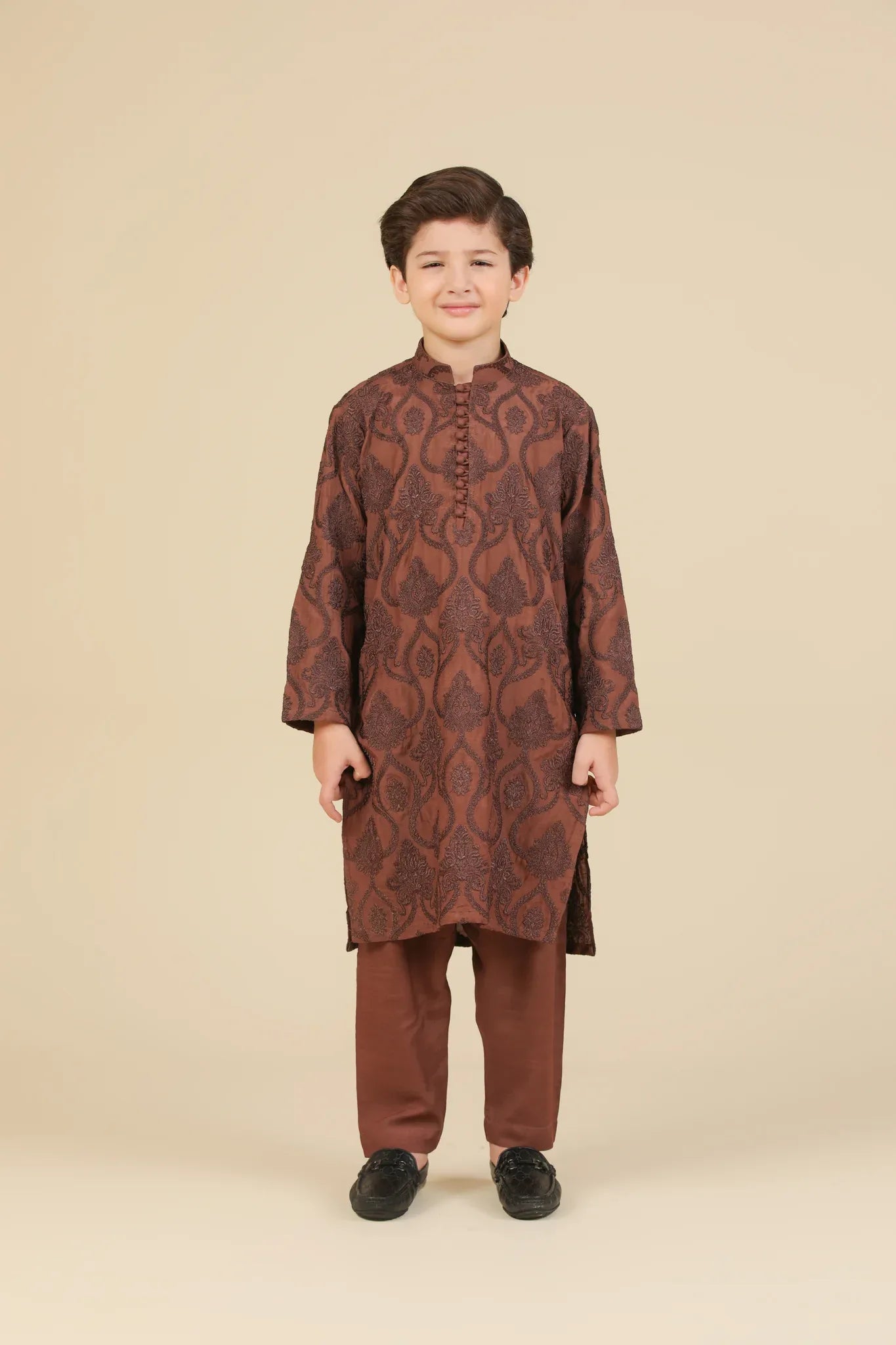 Child wearing a cocoa brown raw silk embroidered kurta with pajama on a beige background