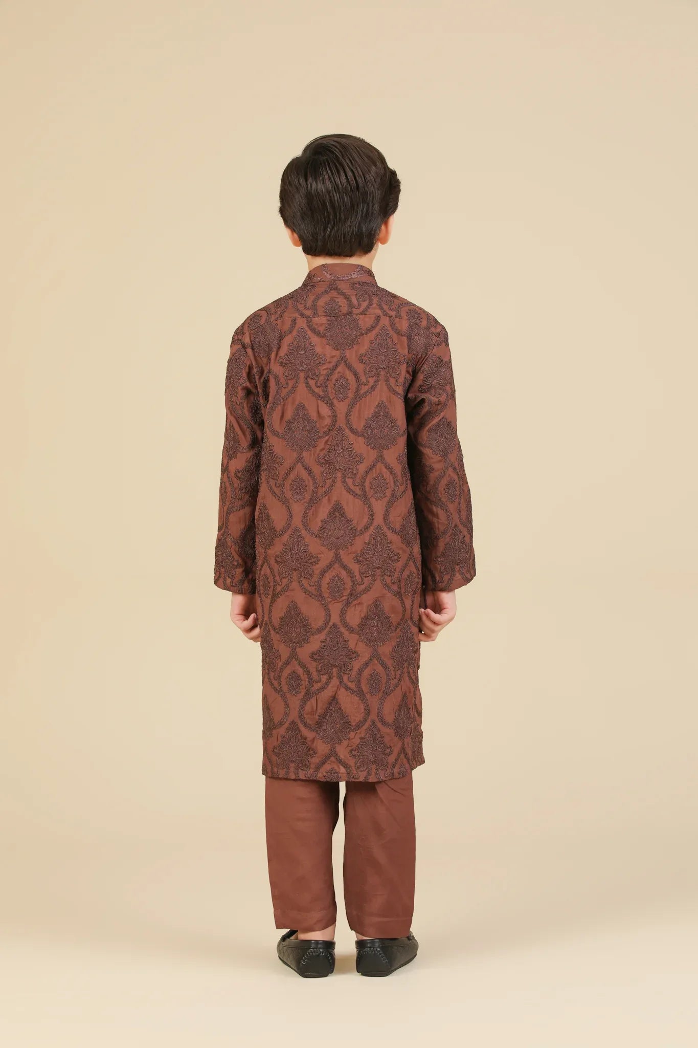 Child wearing a cocoa brown raw silk embroidered kurta with pajama on a beige background