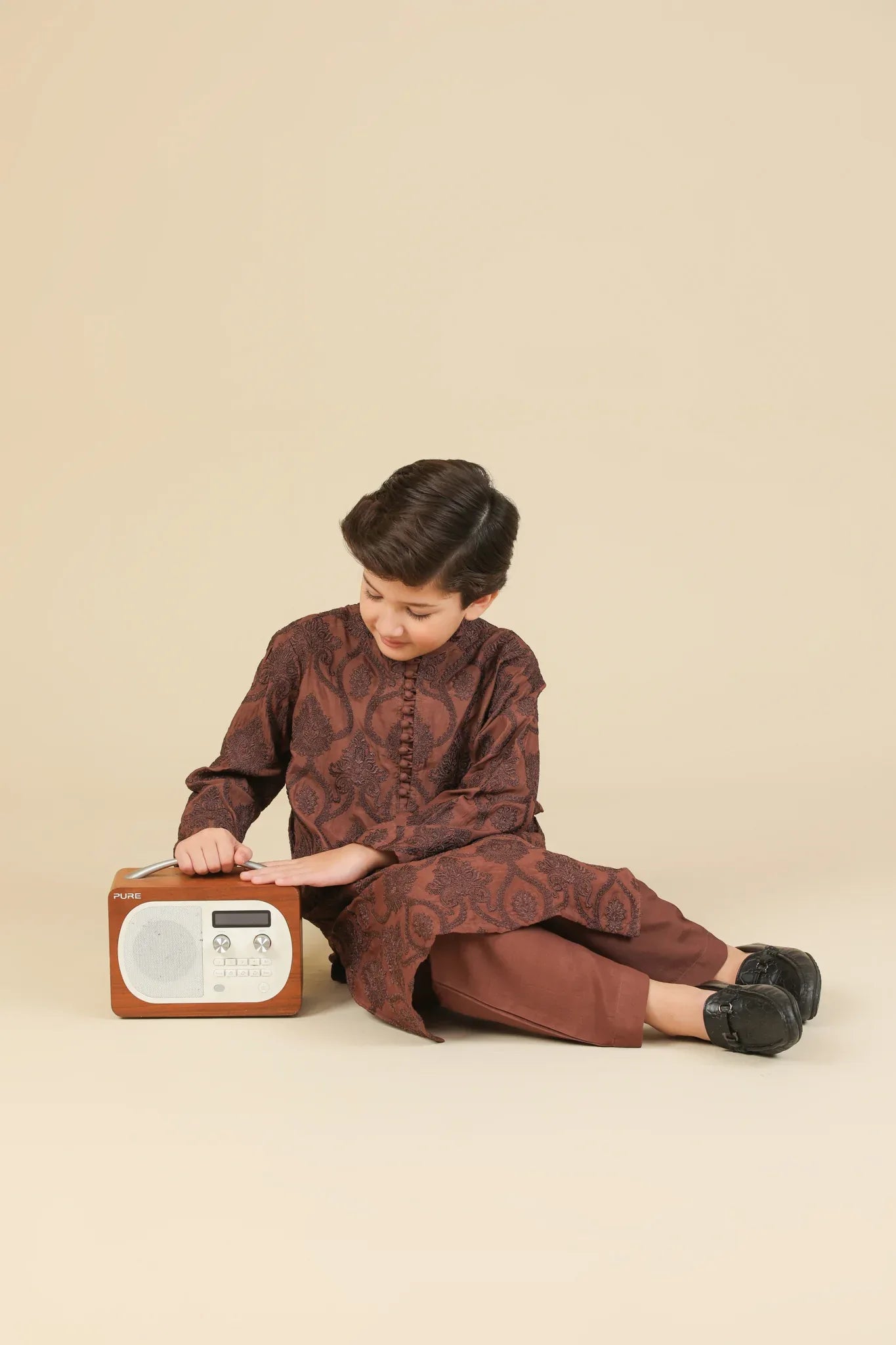 Child wearing a cocoa brown raw silk embroidered kurta with pajama on a beige background