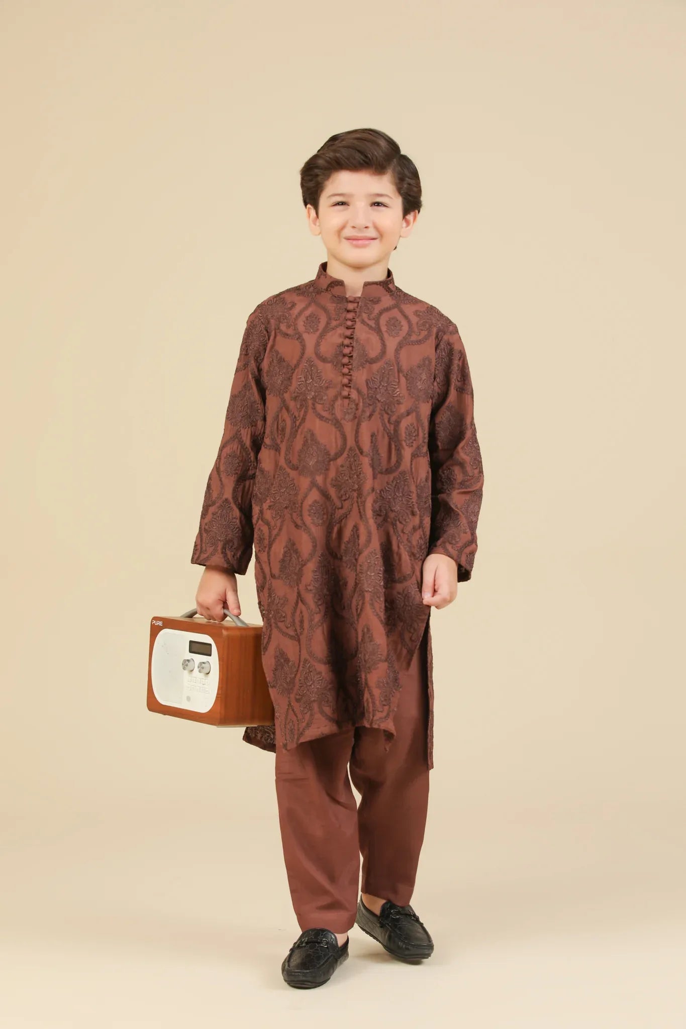 Child wearing a brown raw silk embroidered kurta with pajama on a beige background