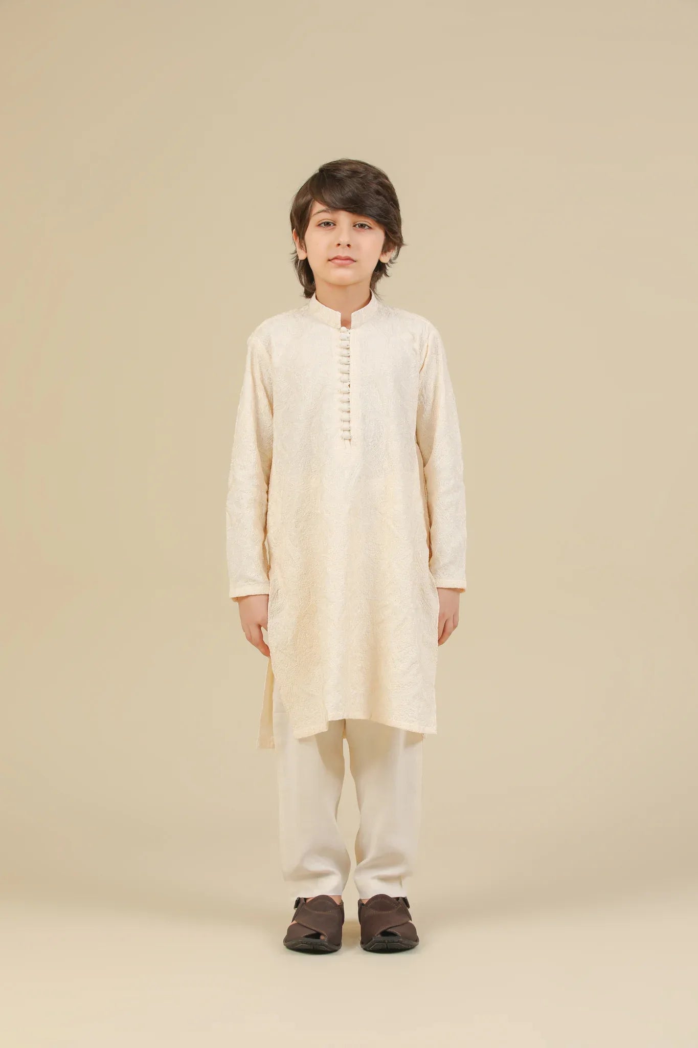Child wearing a bosky white raw silk embroidered kurta trouser on a beige background