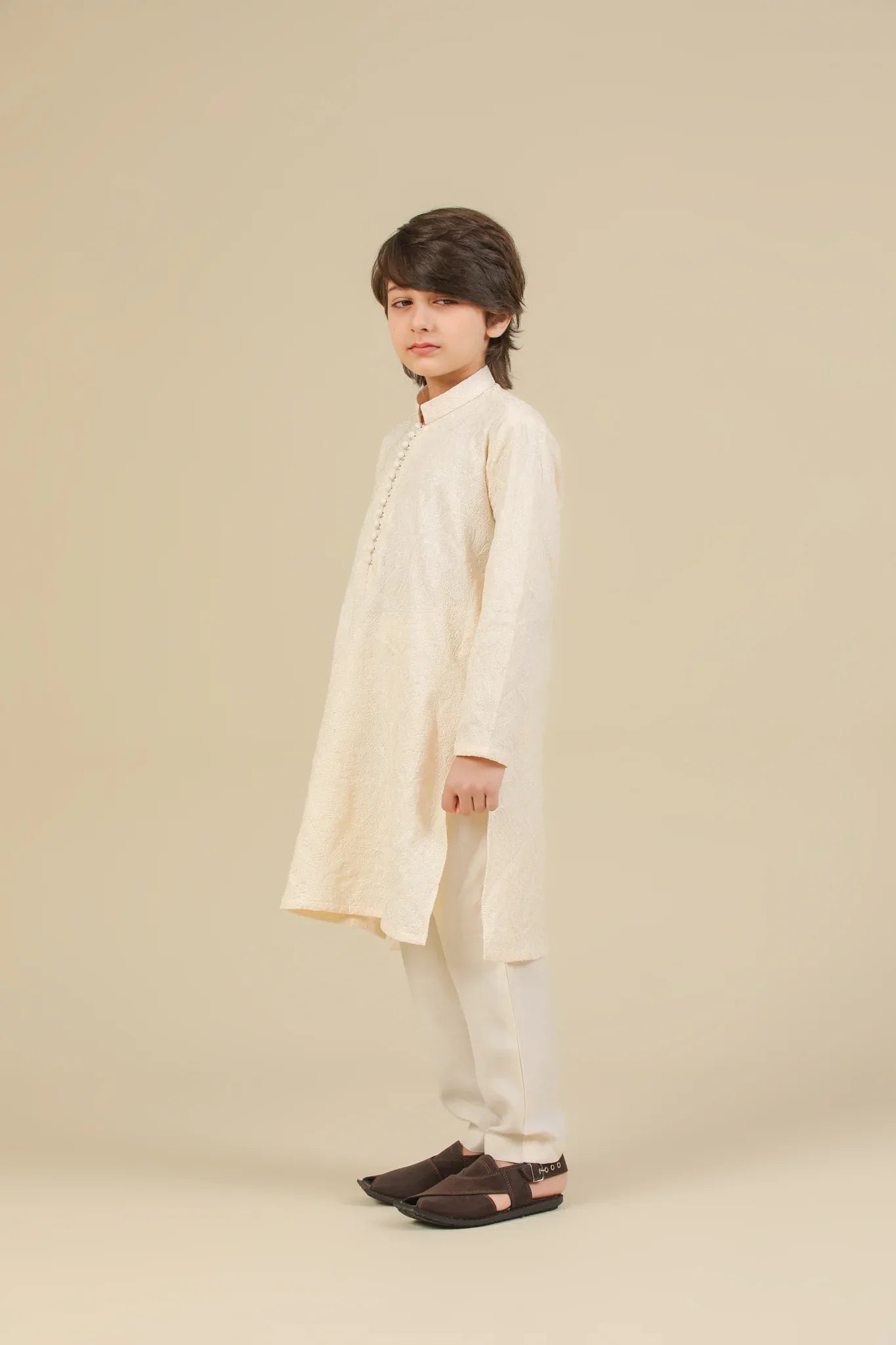 Child wearing a bosky white raw silk embroidered kurta trouser on a beige background