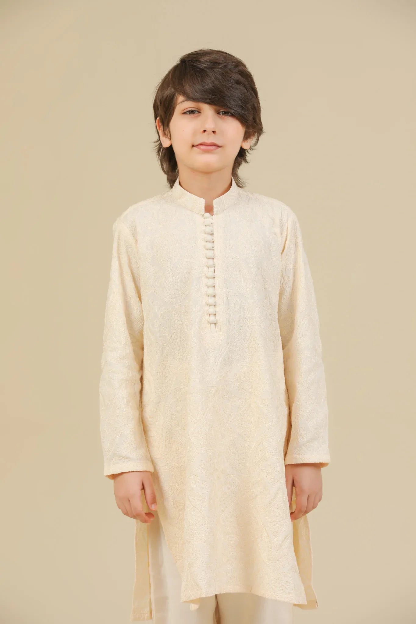 Child wearing a bosky white raw silk embroidered kurta trouser on a beige background