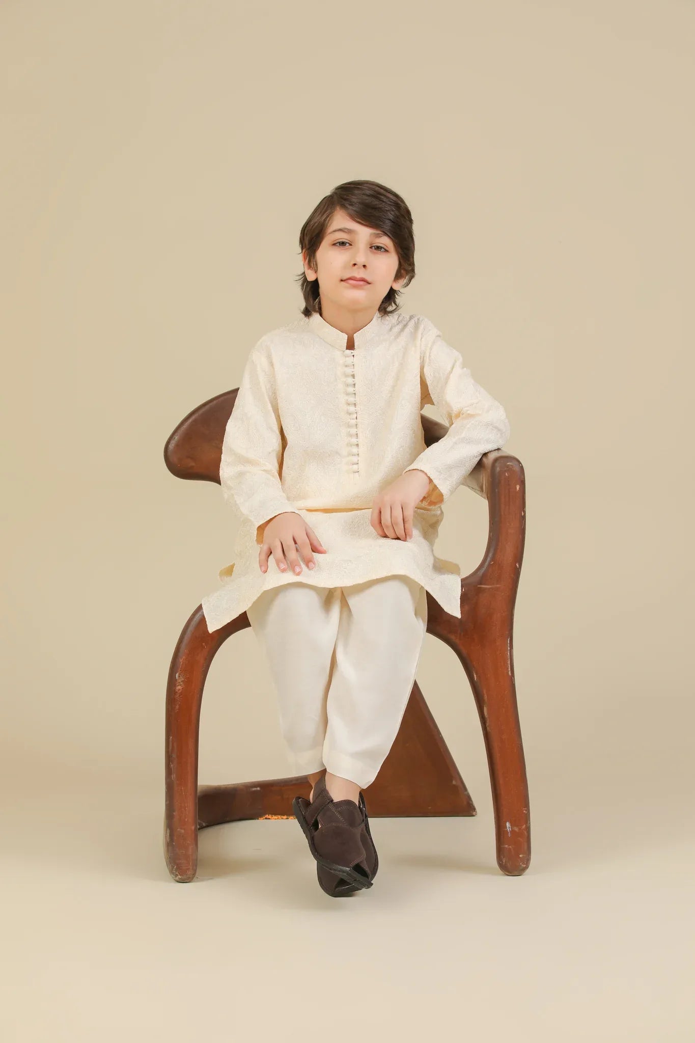Child wearing a bosky white raw silk embroidered kurta trouser on a beige background