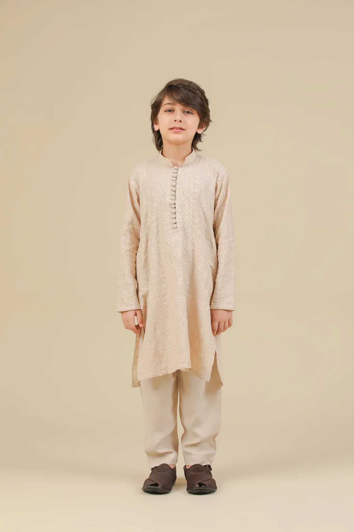 Child wearing a beige raw silk embroidered kurta trouser on a beige background