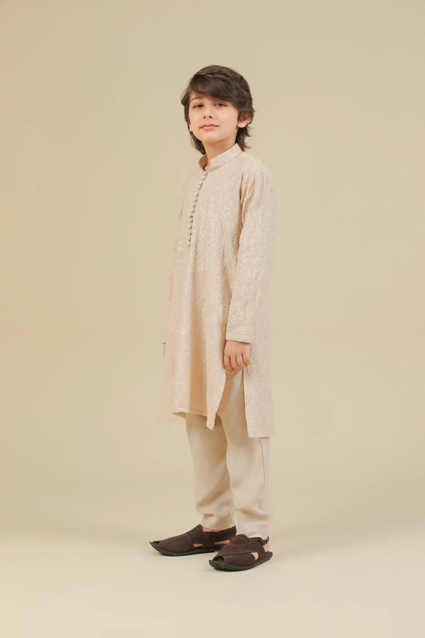 Child wearing a beige raw silk embroidered kurta trouser on a beige background