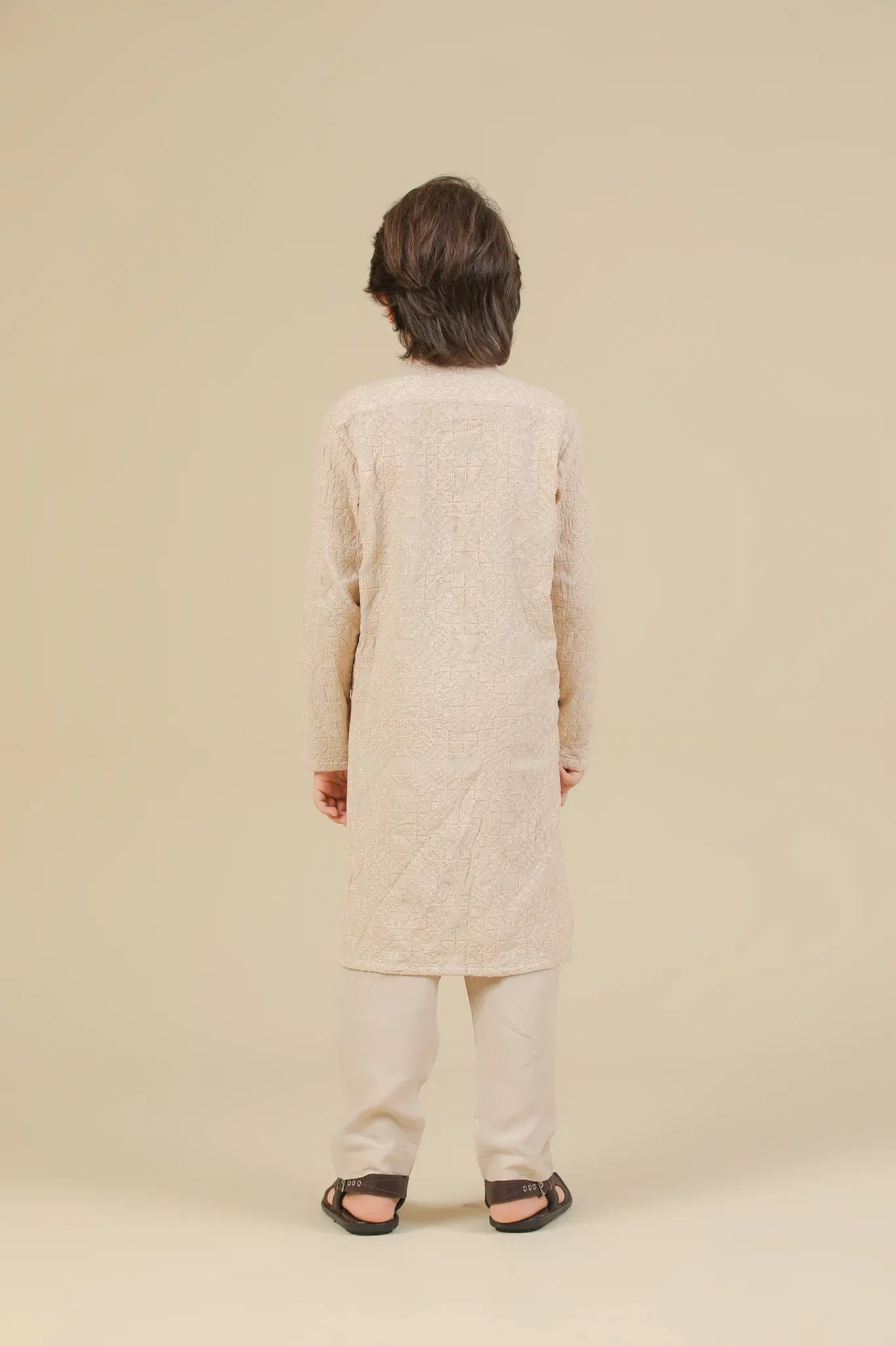 Child wearing a beige raw silk embroidered kurta trouser on a beige background
