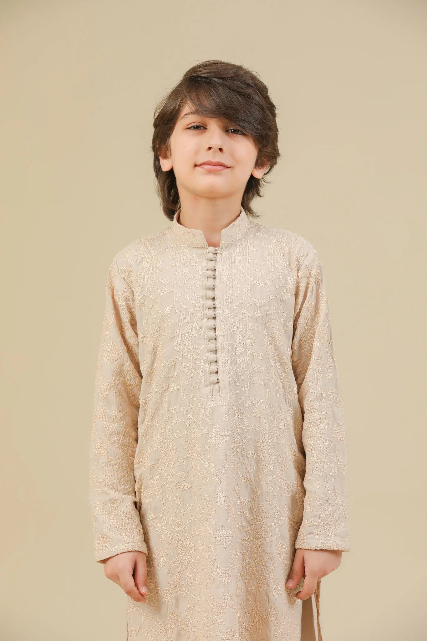 Child wearing a beige raw silk embroidered kurta trouser on a beige background