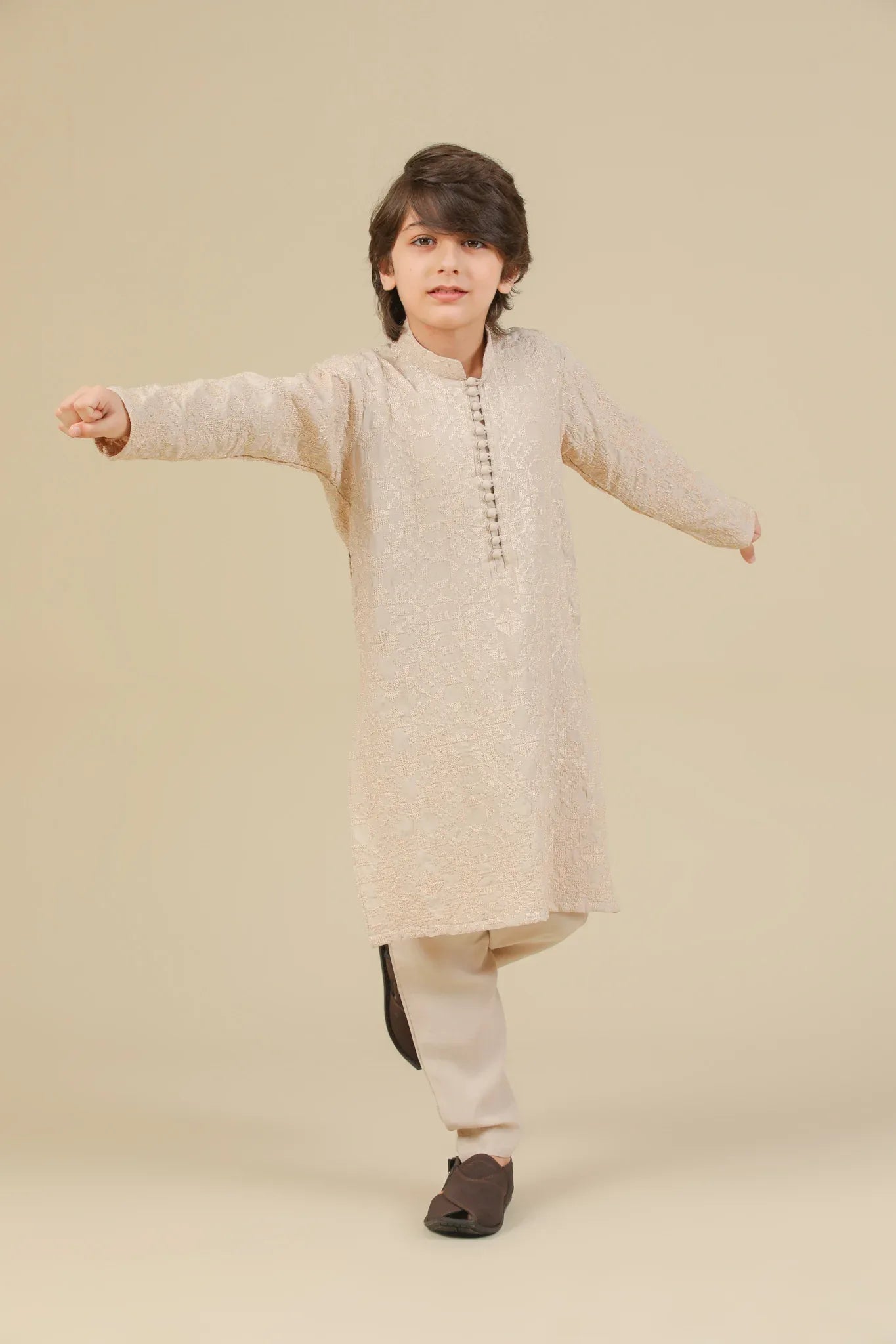Child wearing a beige raw silk embroidered kurta trouser on a beige background