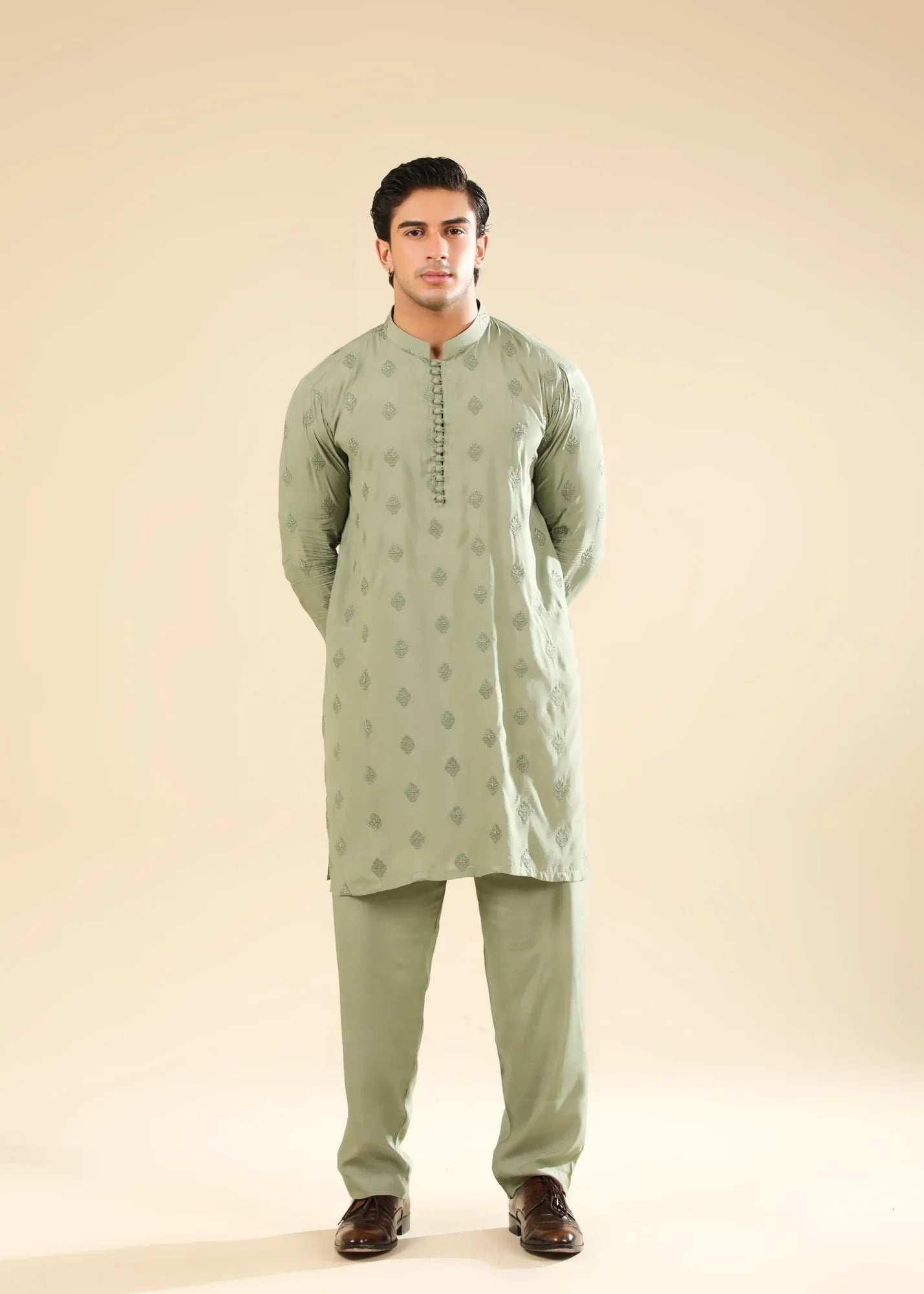 Man wearing a light green raw silk embroidered kurta with a beige backgroung