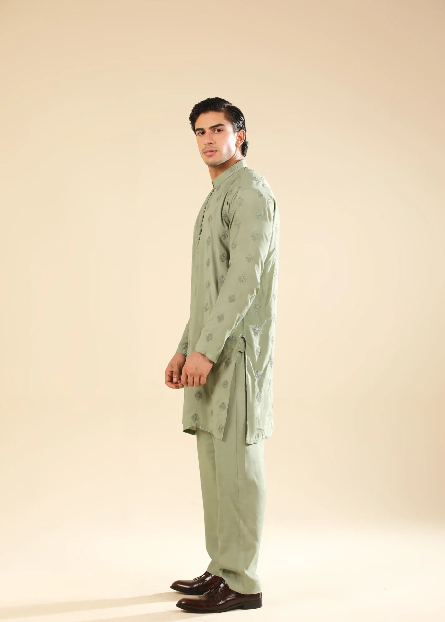 Man wearing a light green raw silk embroidered kurta with a beige backgroung