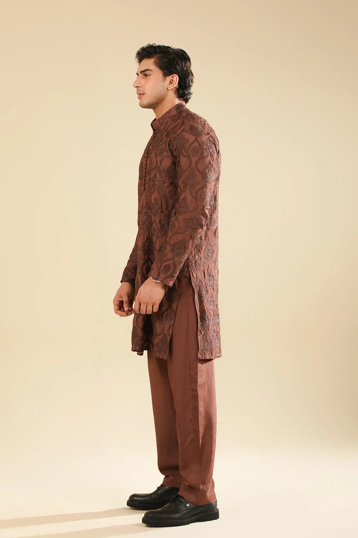 Man wearing a cocoa brown raw silk embroidered kurta trouser against a beige background