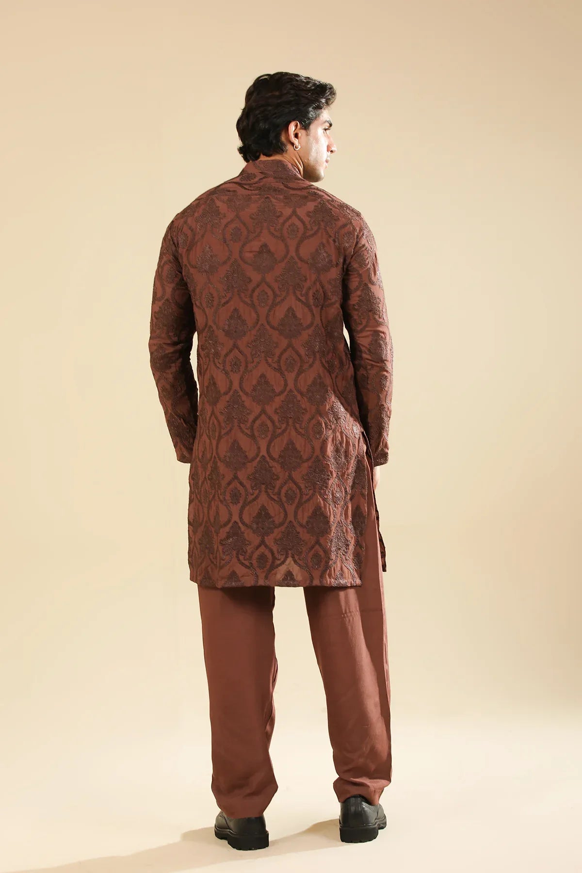 Man wearing a cocoa brown raw silk embroidered kurta trouser against a beige background