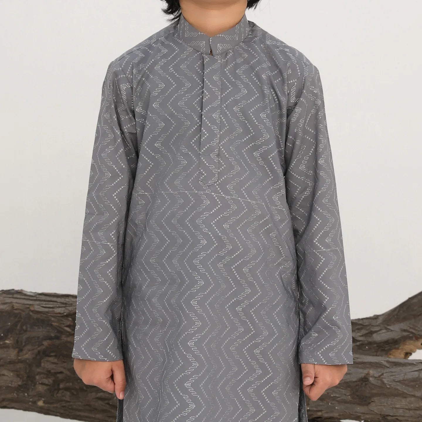 A child wearing a light grey embroidered kurta with a mandarin collar and full sleeves, paired with plain cotton trousers.