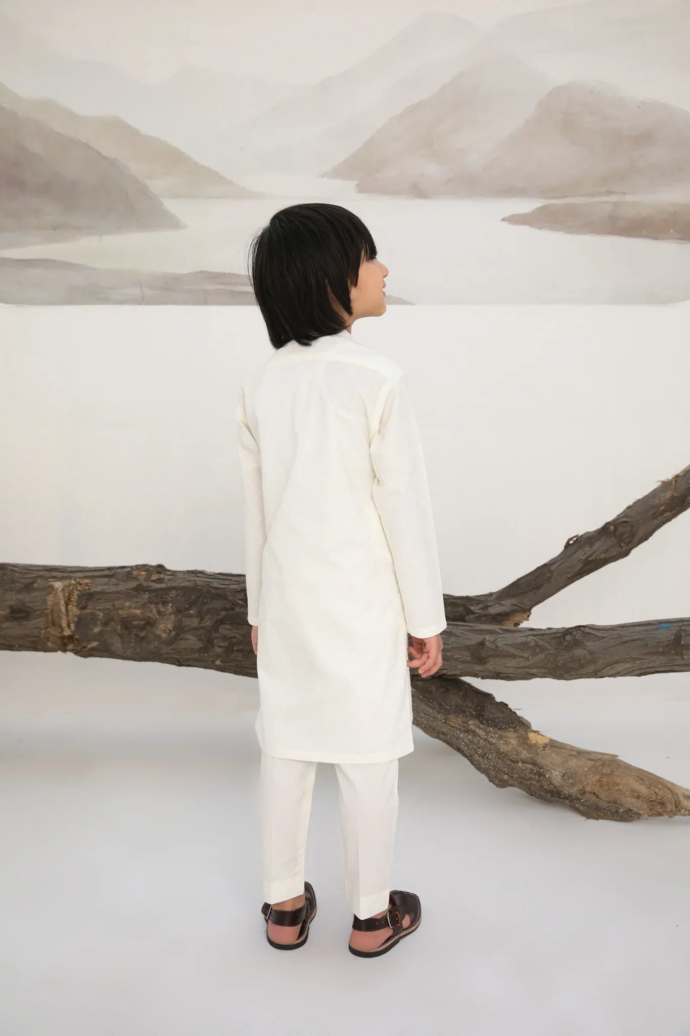 A child wearing a white cotton embroidered kurta trouser
