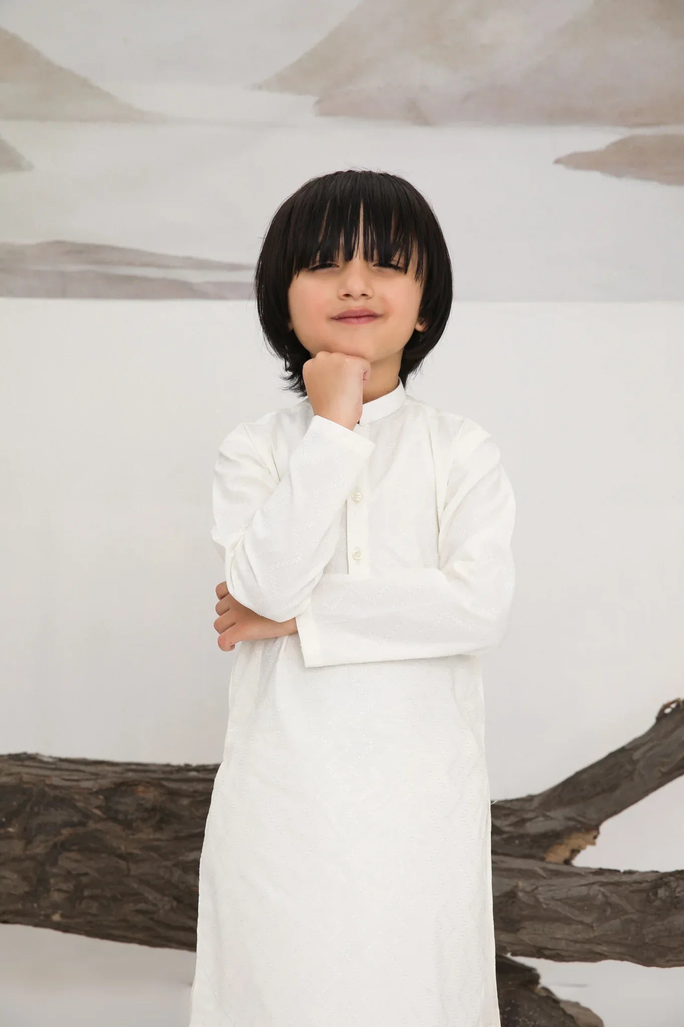 A child wearing a white cotton embroidered kurta trouser