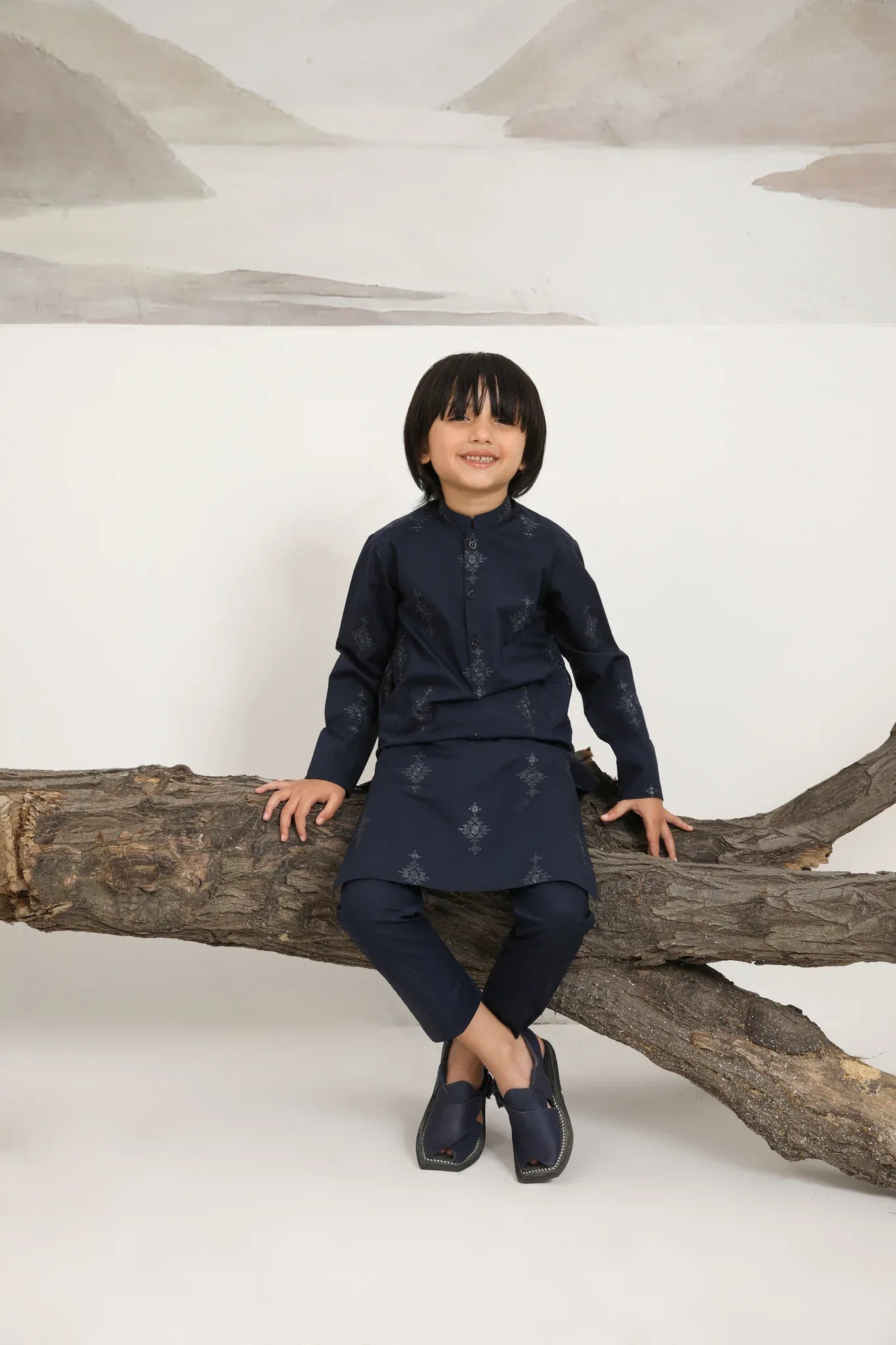 A child wearing a navy blue cotton embroidered kurta trouser
