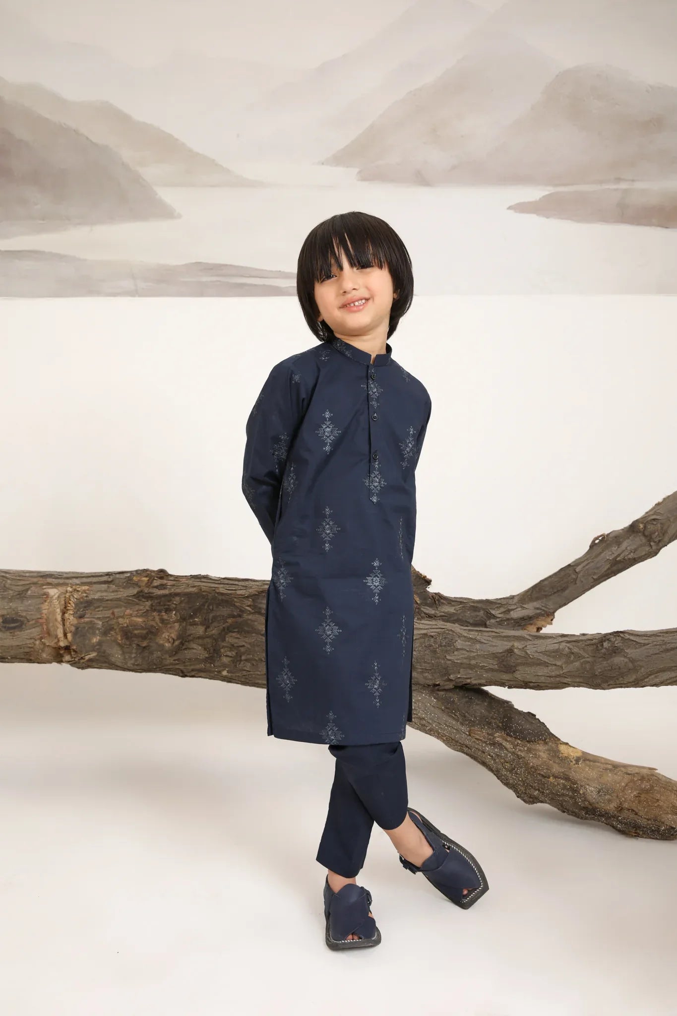 A child wearing a navy blue cotton embroidered kurta trouser