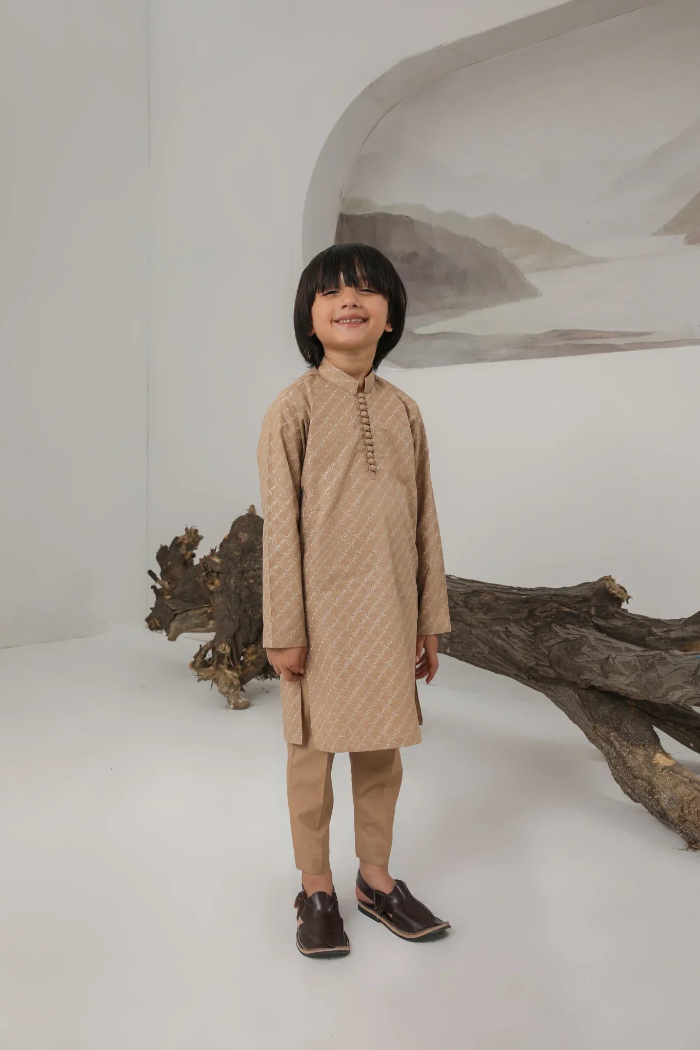 A child wearing a camel embroidered cotton kurta and trouser with a mandarin collar.