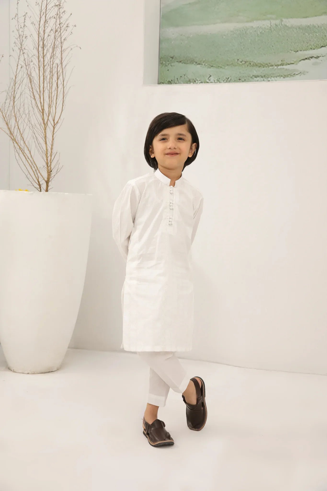 A child wearing an off white cotton embroidered kurta trouser