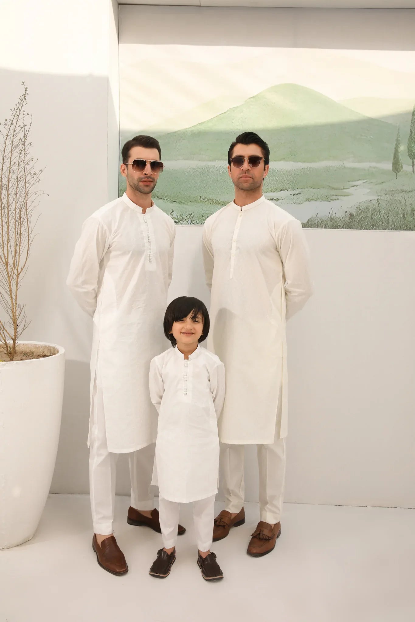 A man wearing a bsoky white cotton kurta embroidered with geometric patterns, featuring a mandarin collar and full sleeves, paired with plain trousers.