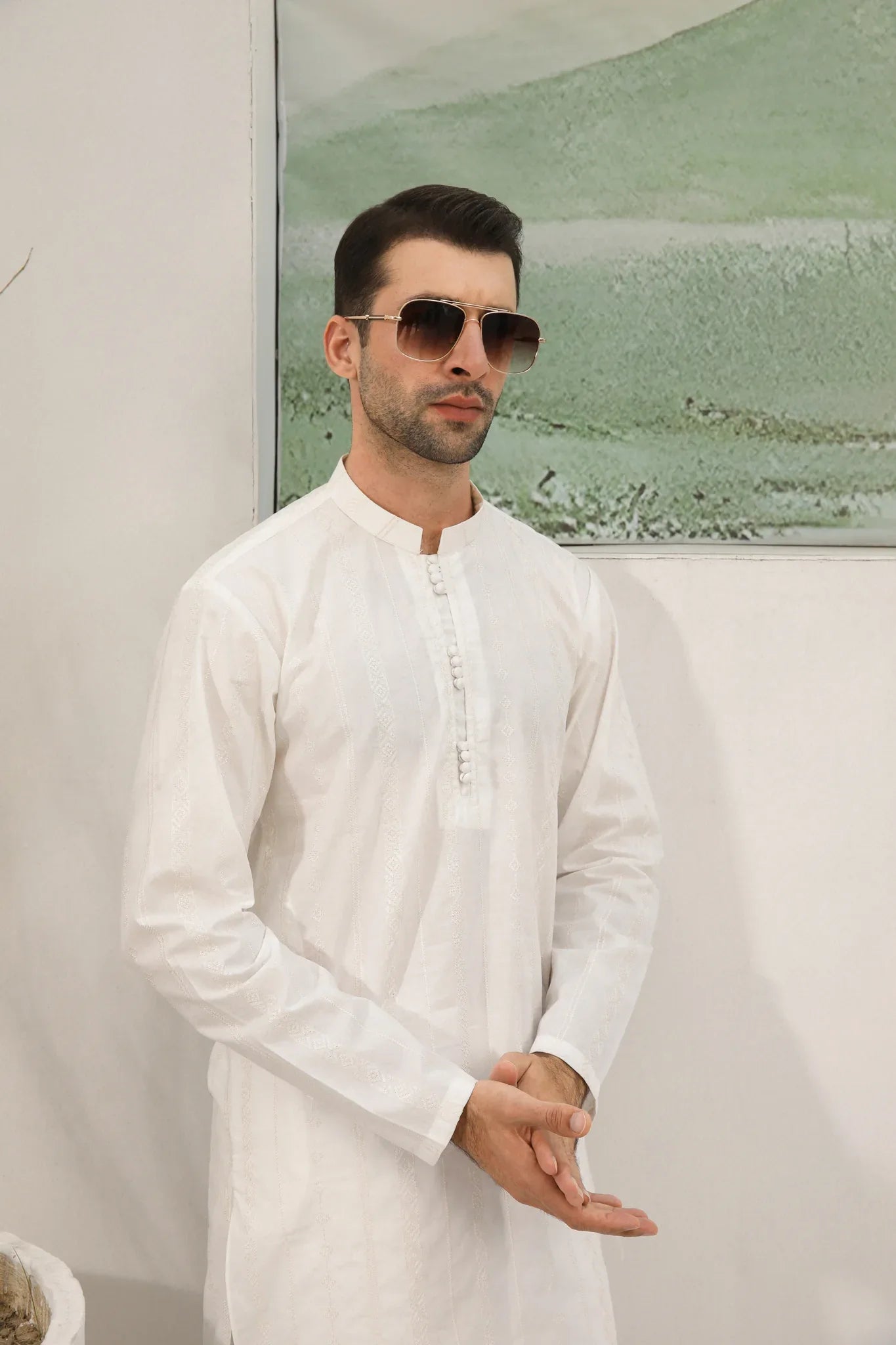 A man wearing a white embroidered kurta trouser with full sleeves in soft cotton fabric.