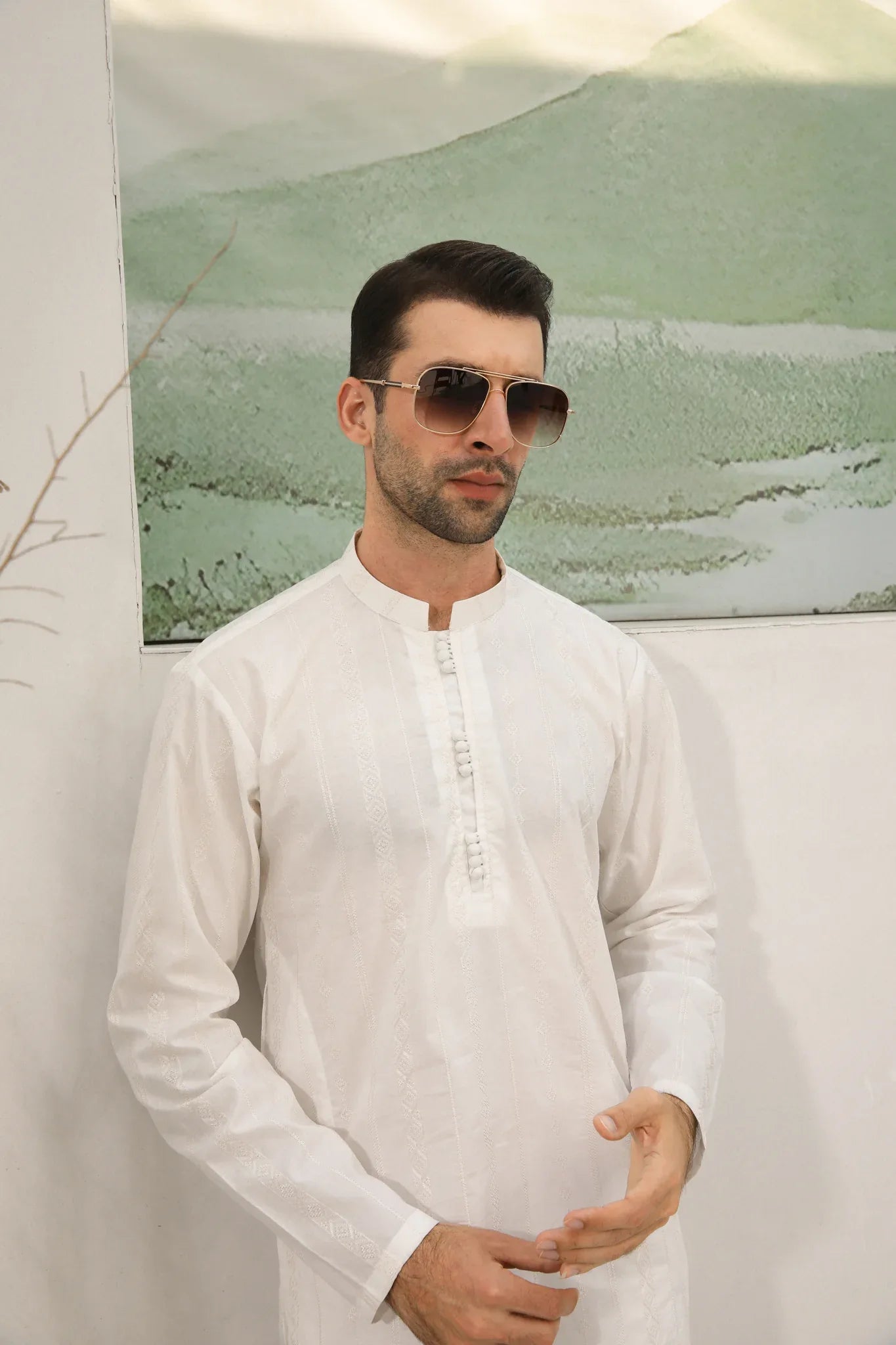 A man wearing a white embroidered kurta trouser with full sleeves in soft cotton fabric.