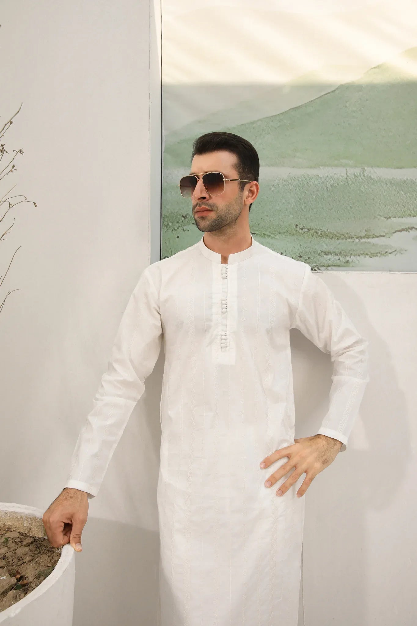 A man wearing a white embroidered kurta trouser with full sleeves in soft cotton fabric.