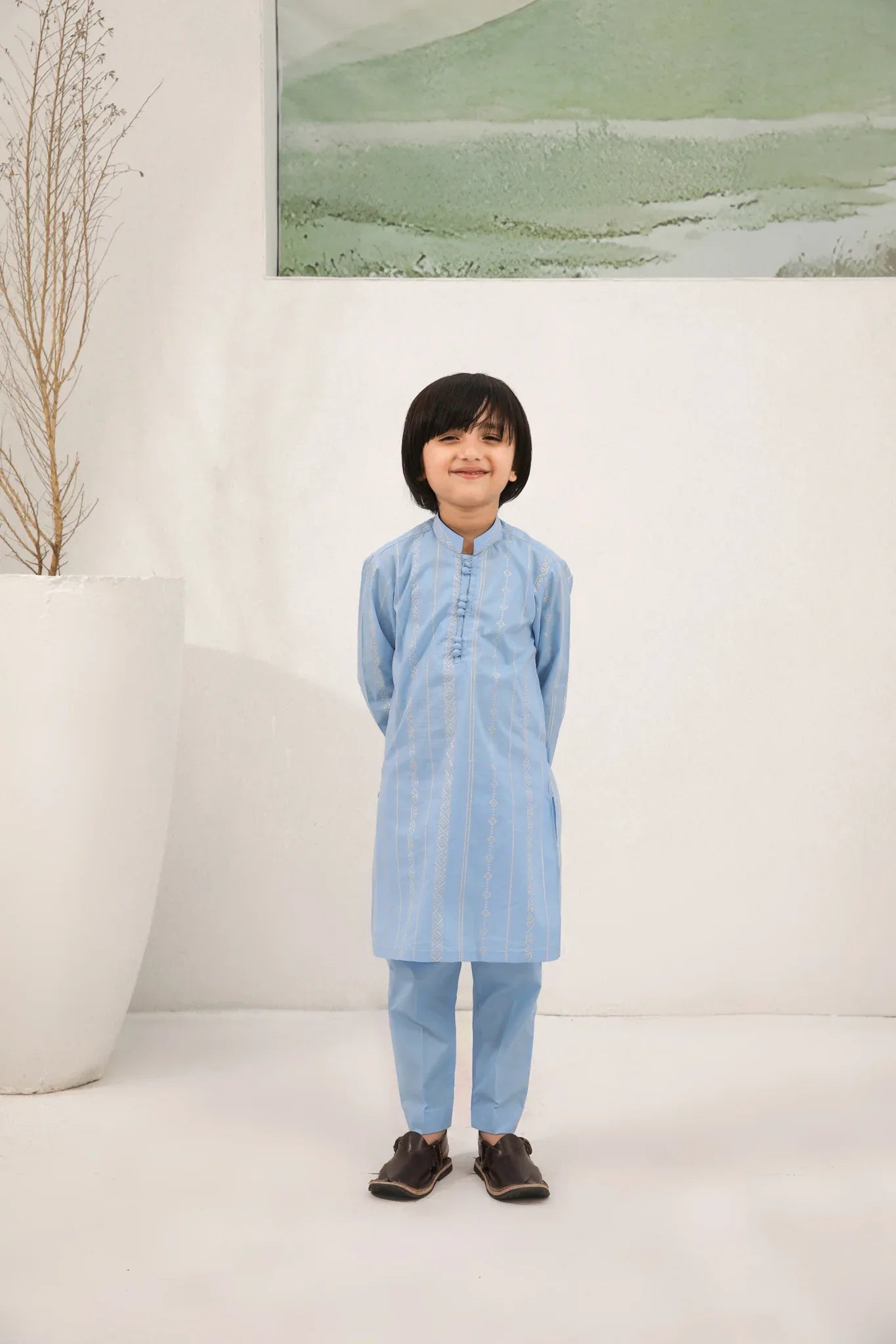 A child wearing a sky blue cotton embroidered kurta trouser