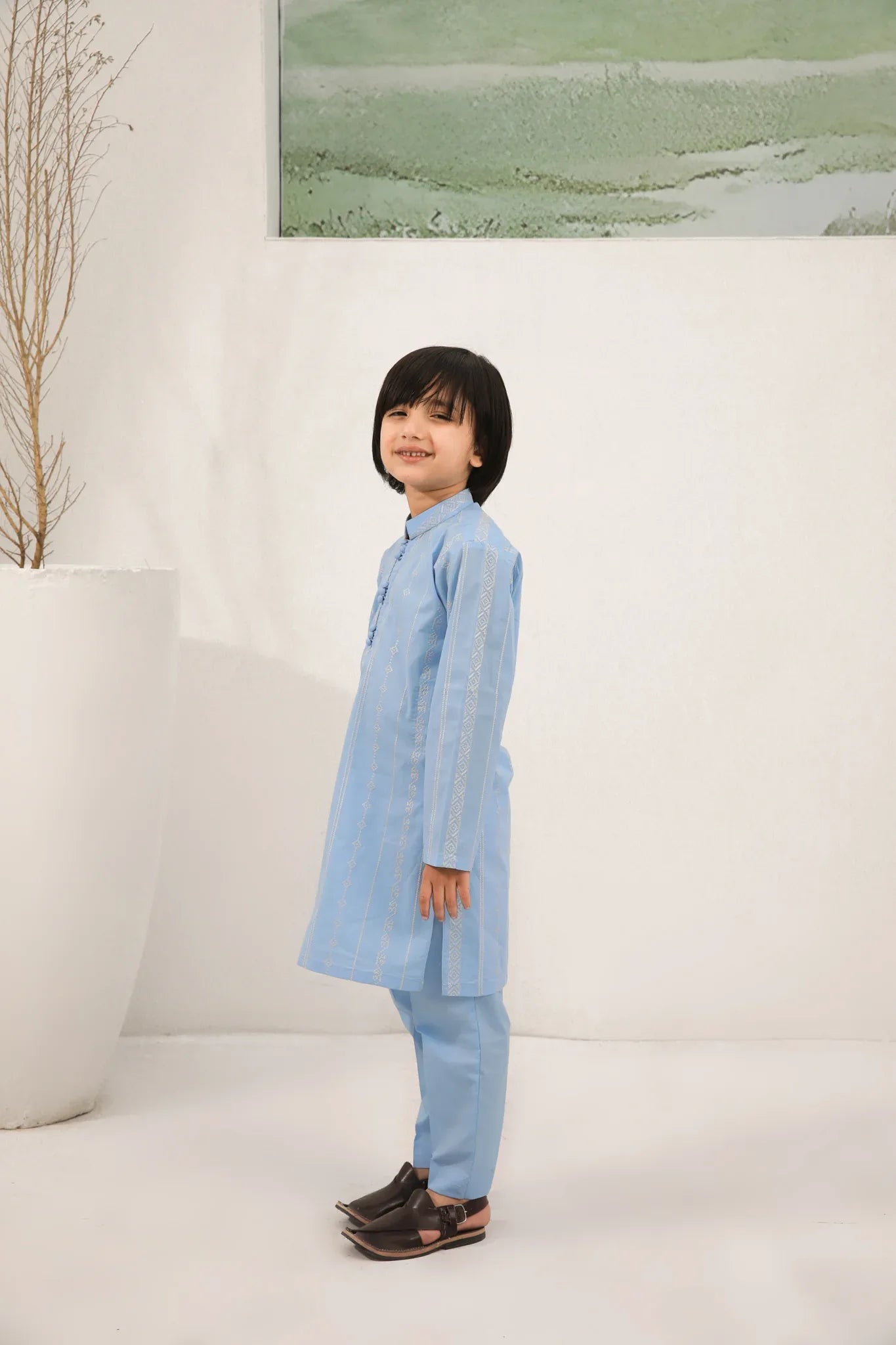 A child wearing a sky blue cotton embroidered kurta trouser