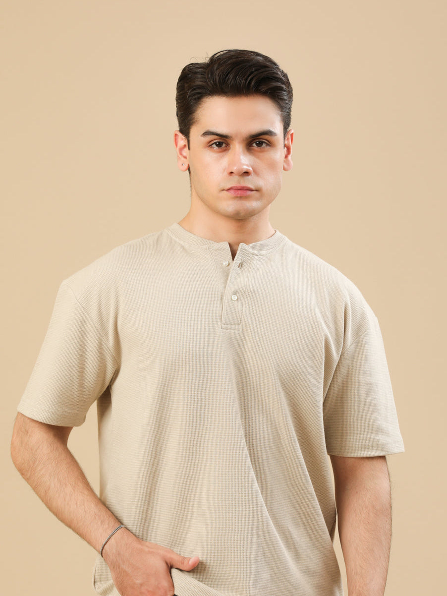 Man wearing a beige shirt and black pants on a beige background